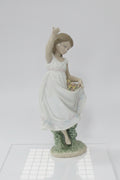 A collection of decorative items on a white studio background, including four small porcelain figurines and a large dark red crystal candle holder with hanging clear crystals.