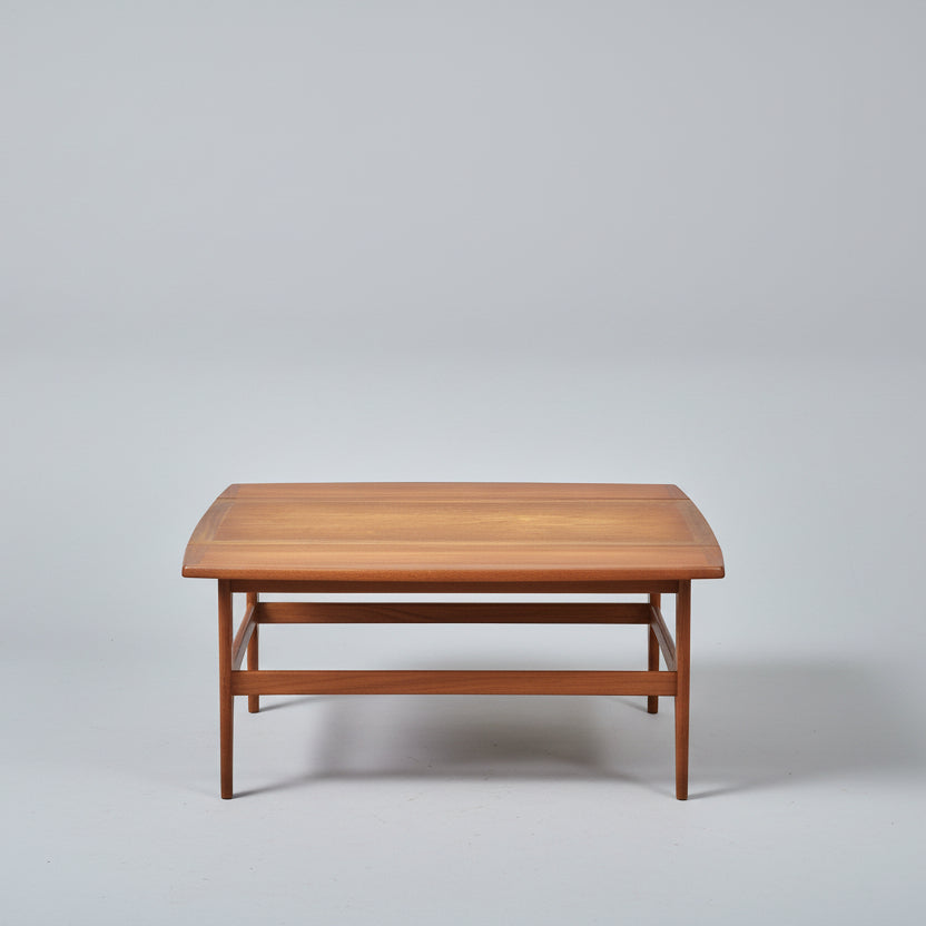Wooden table on a red patterned rug with a bicycle in the background