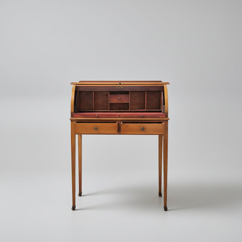 Wooden roll-top desk with a clock on a red patterned rug
