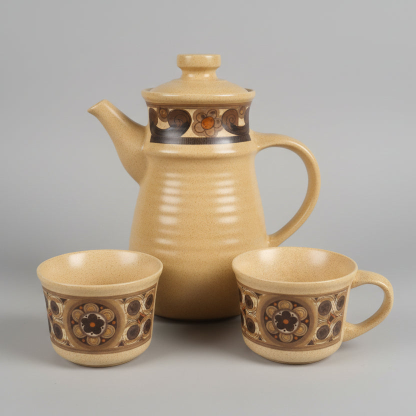 Set of ceramic teapots and cups with decorative patterns on a white surface.