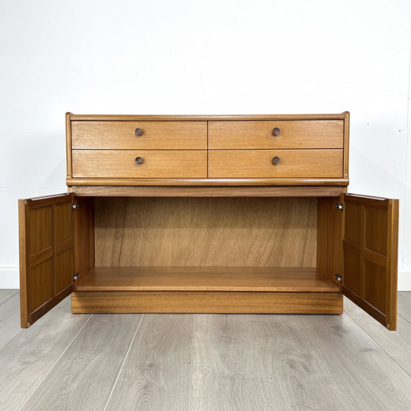Wooden cabinet with open doors on a light wooden floor and white wall background