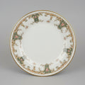 Decorative plate with intricate patterns held in a hand, with a cluttered background.