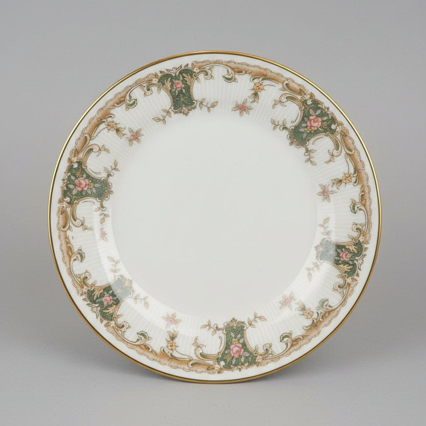 Decorative plate with intricate patterns held in a hand, with a cluttered background.