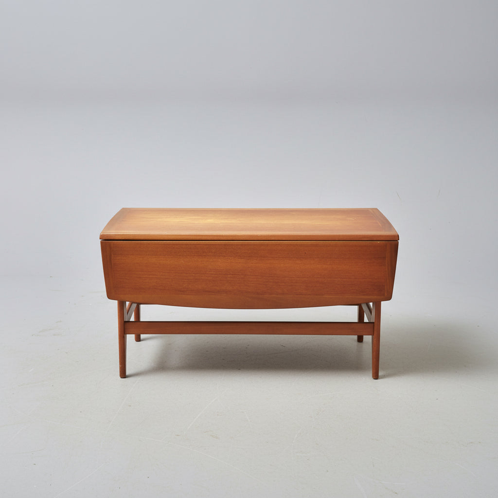 Wooden coffee table on a patterned red rug with a wooden cabinet in the background.