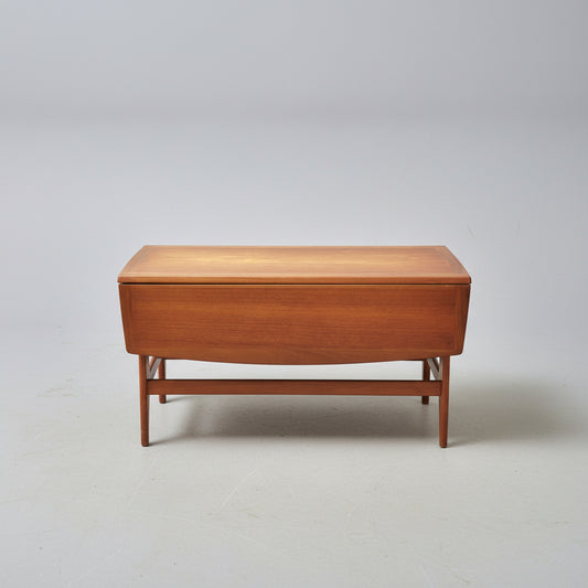 Wooden coffee table on a patterned red rug with a wooden cabinet in the background.