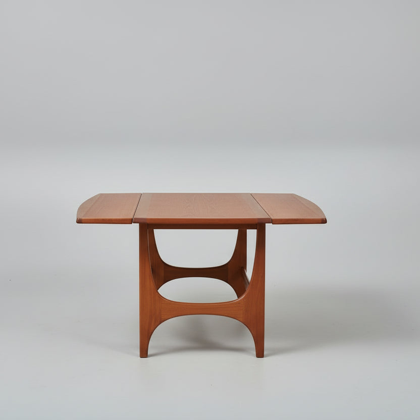Wooden dining table with a bicycle in the background on a patterned rug.
