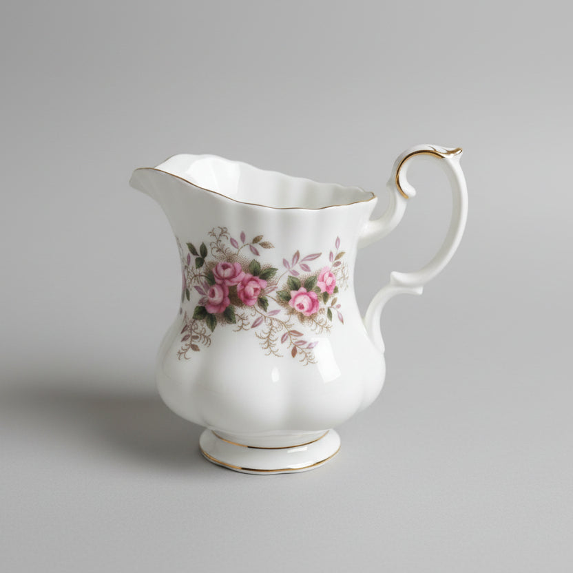 White ceramic pitcher with floral design on a gray background