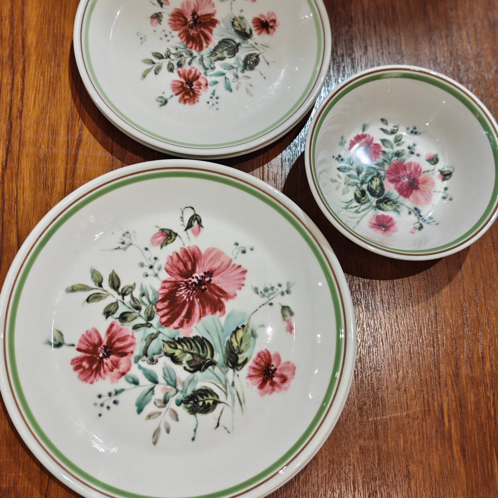 Three ceramic plates with floral designs on a wooden surface