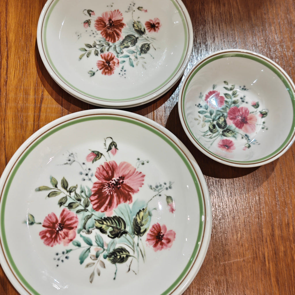 Three ceramic plates with floral designs on a wooden surface