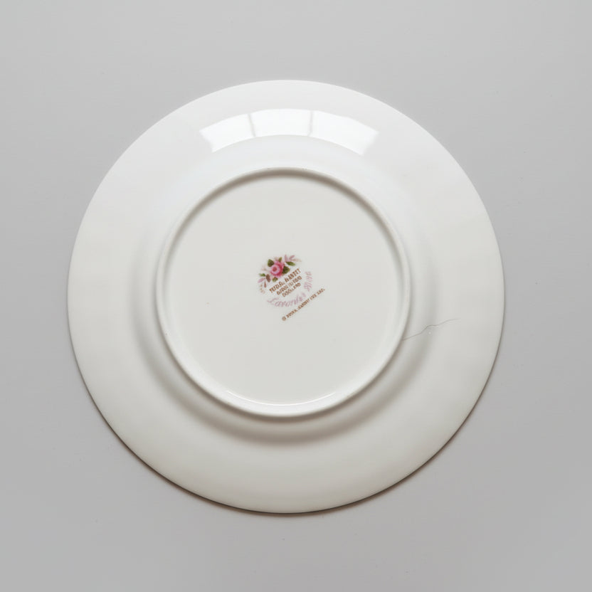White ceramic plate with a logo on a gray background