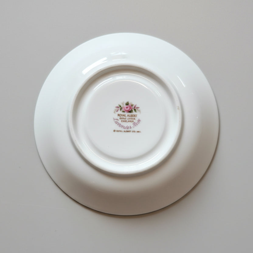 White ceramic plate with a visible brand logo on a wooden surface