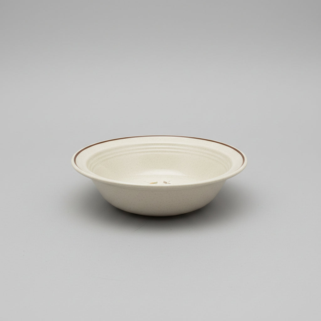 Ceramic bowl with floral design on a wooden surface, blurred shelves in the background