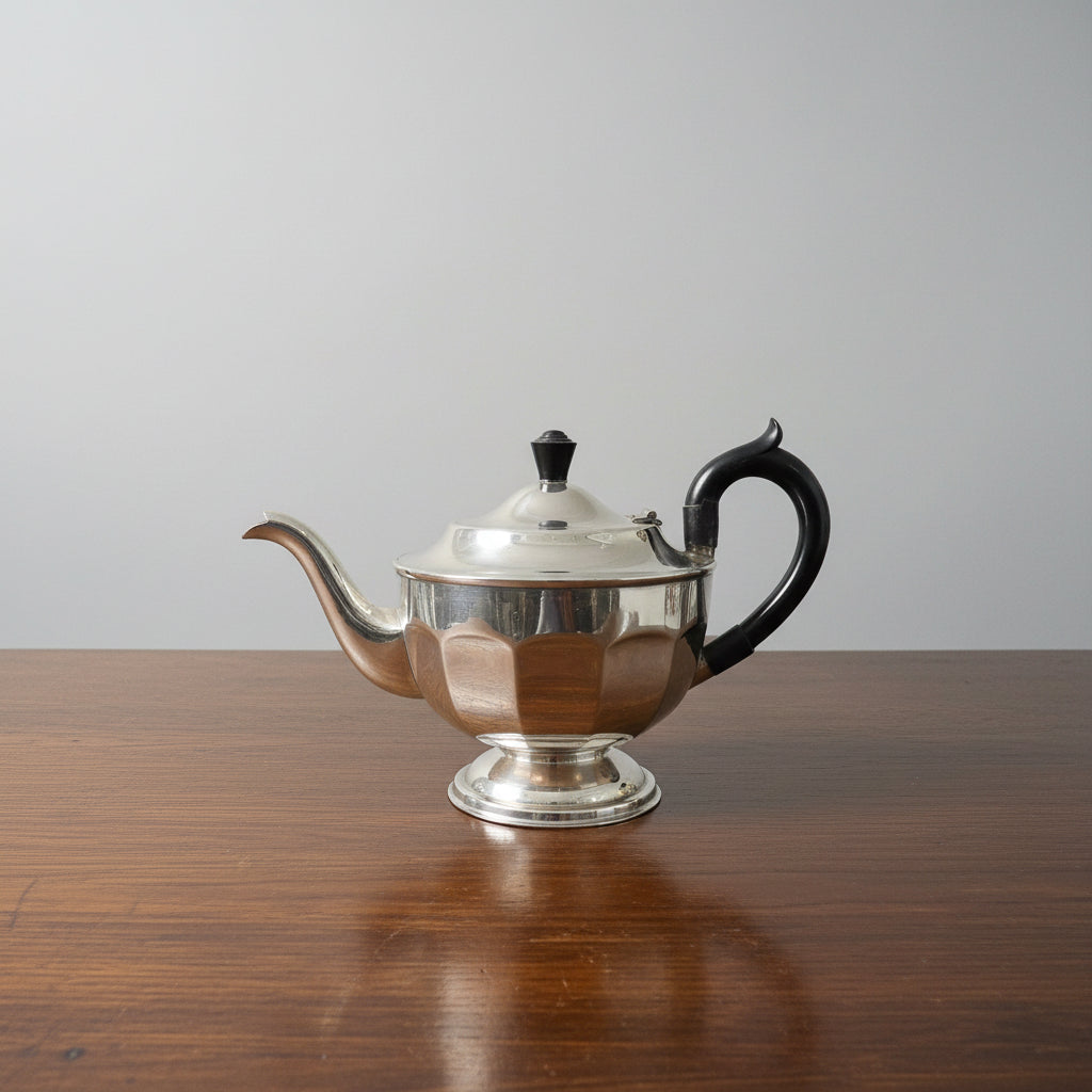 Silver teapot with black handle