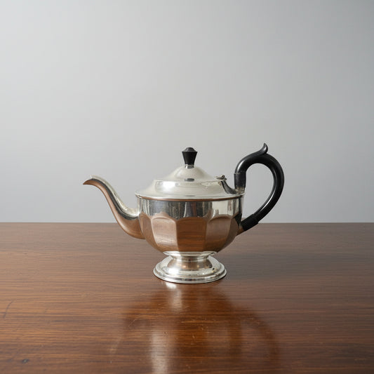 Silver teapot with black handle