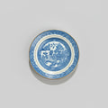 Blue and white ceramic plate with intricate design on a gray background