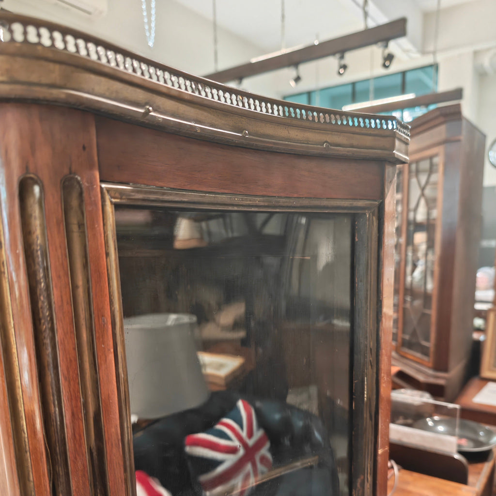 Vintage wooden cabinet with glass doors displaying a Union Jack flag, in an indoor setting.