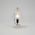 Decorative wall sconce with intricate design on a wooden surface.