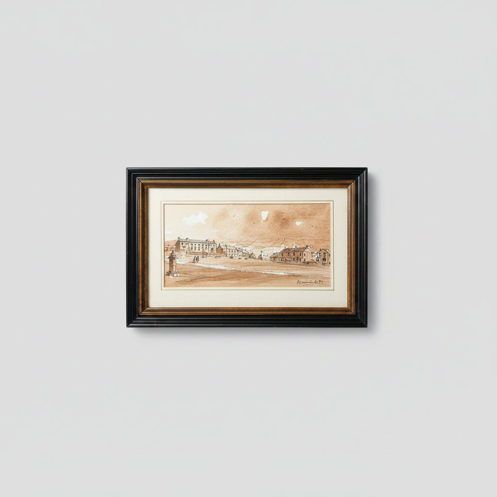 A framed watercolor landscape print depicting a coastal town scene, mounted on a wooden wall. The artwork features warm sepia and brown tones with a black double-frame and white matting.