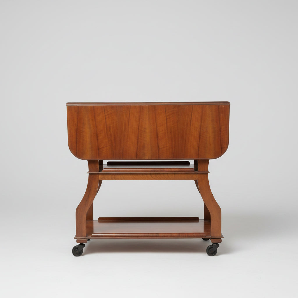 Wooden side table with a shelf on a red patterned rug against a light gray wall.