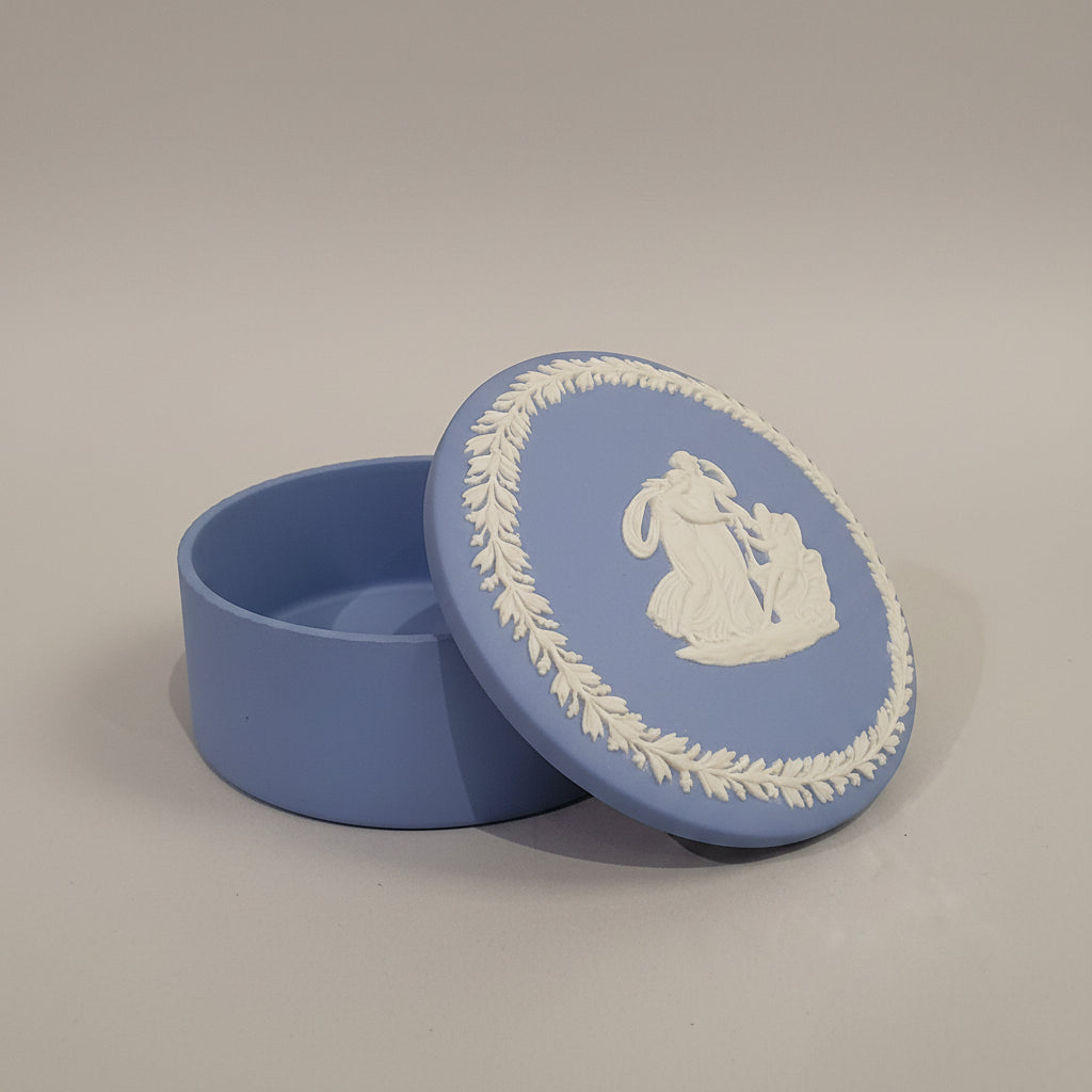 Blue Wedgwood plate with white relief design on a beige background