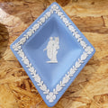 A blue and white Wedgewood Jasperware trinket dish with floral patterns and a classical figure design.