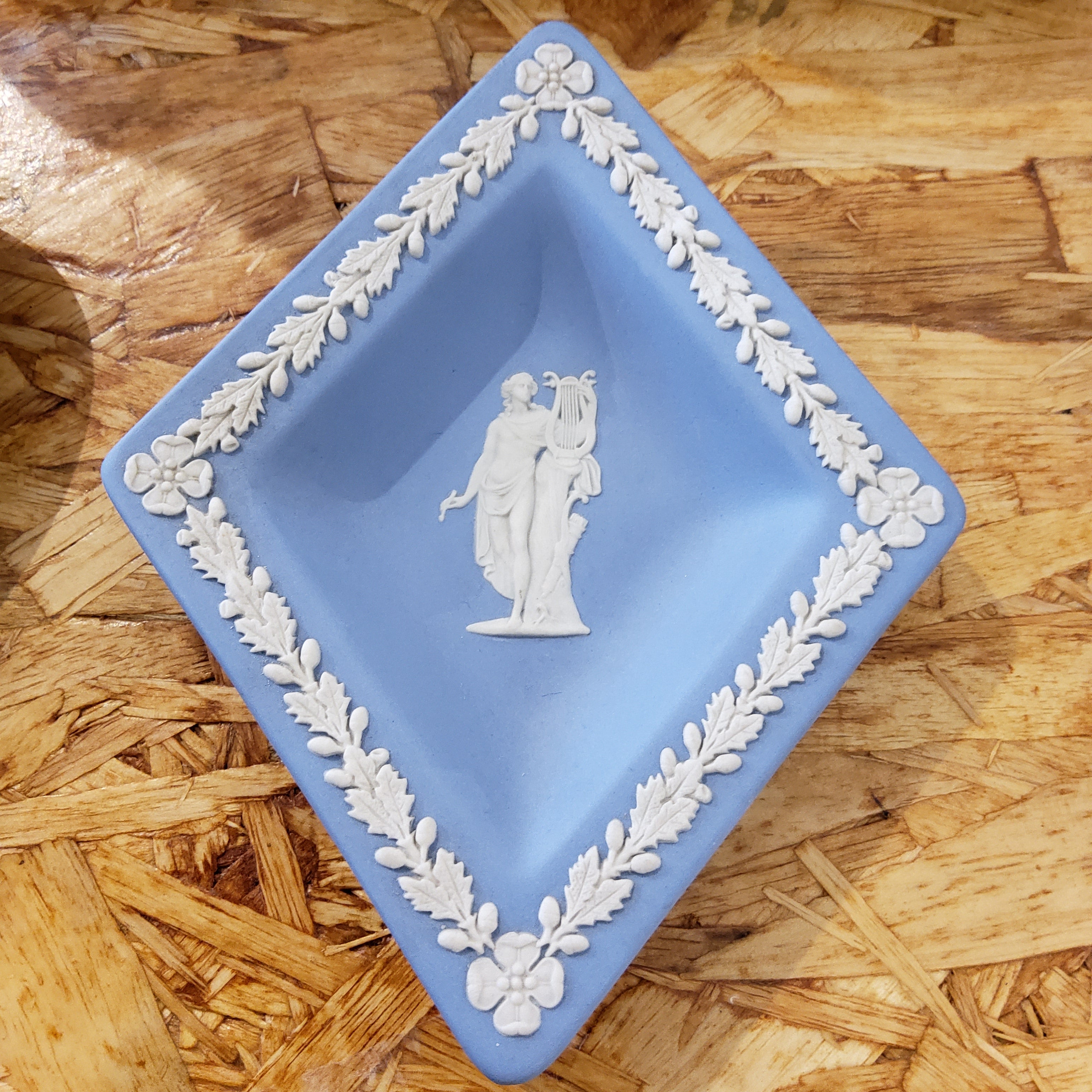 A blue and white Wedgewood Jasperware trinket dish with floral patterns and a classical figure design.