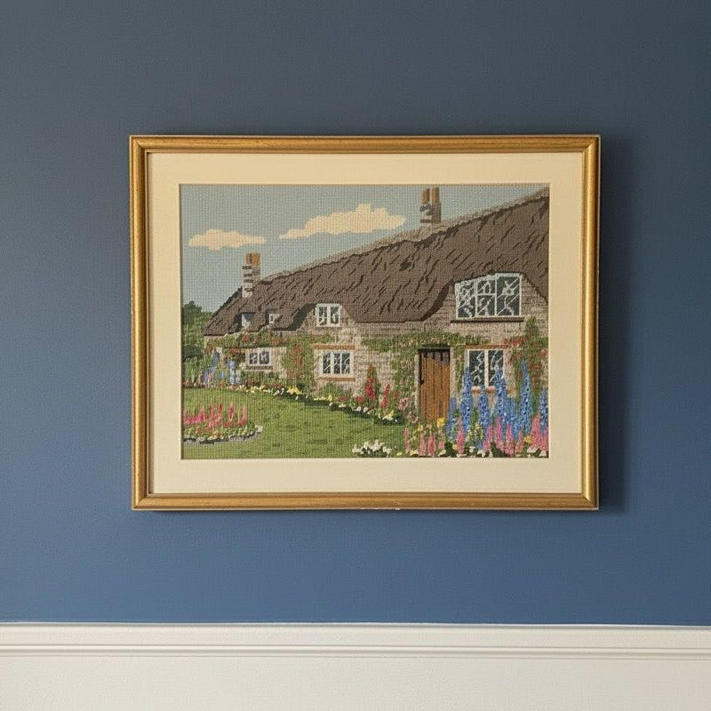 Vintage needle point art work of Thatch roof cottage