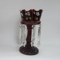 A collection of decorative items on a white studio background, including four   a large dark red crystal candle holder with hanging clear crystals.