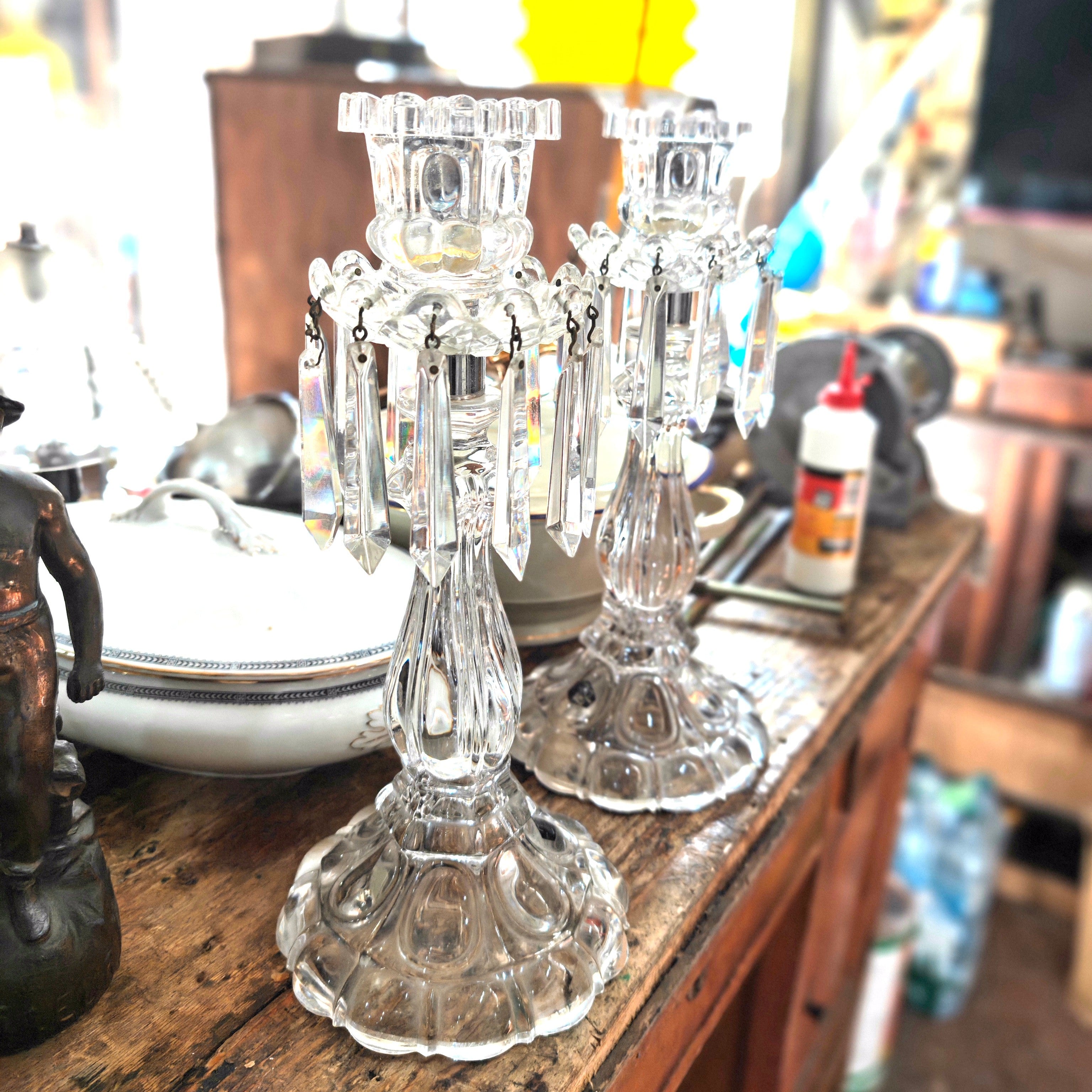 Two crystal candelabras on a wooden surface with a blurred background