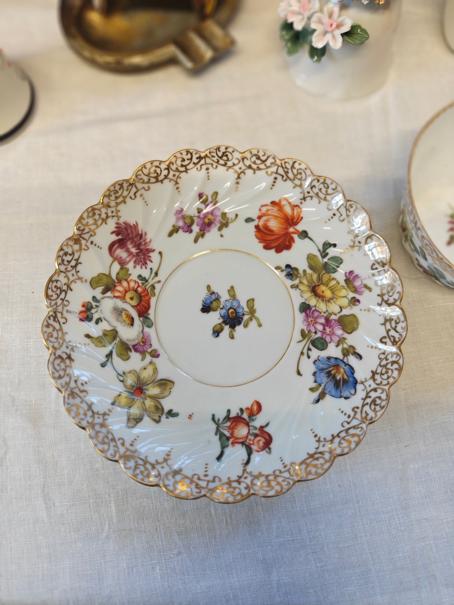 Dresden tea cup and saucer set features a delicate floral design with intricate gold accents