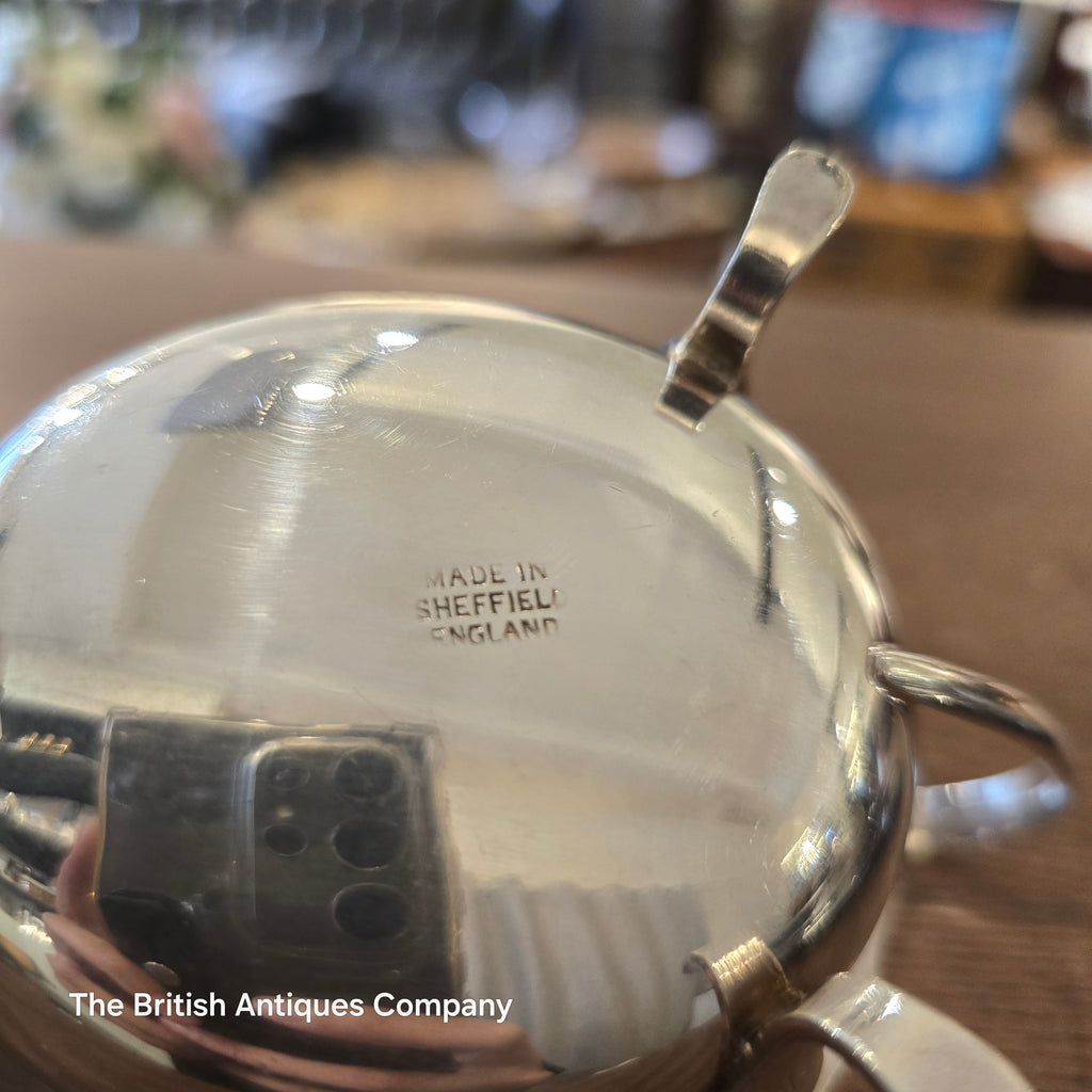 Close-up of a silver gravy boat with 'Made in Sheffield, England' engraving.