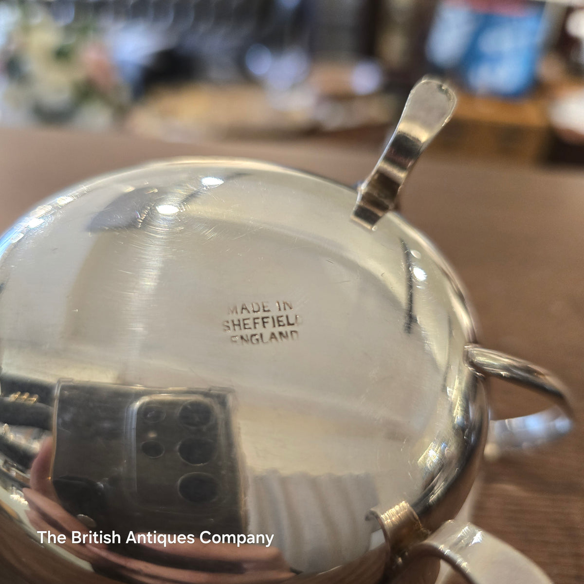 Close-up of a silver gravy boat with 'Made in Sheffield, England' engraving.