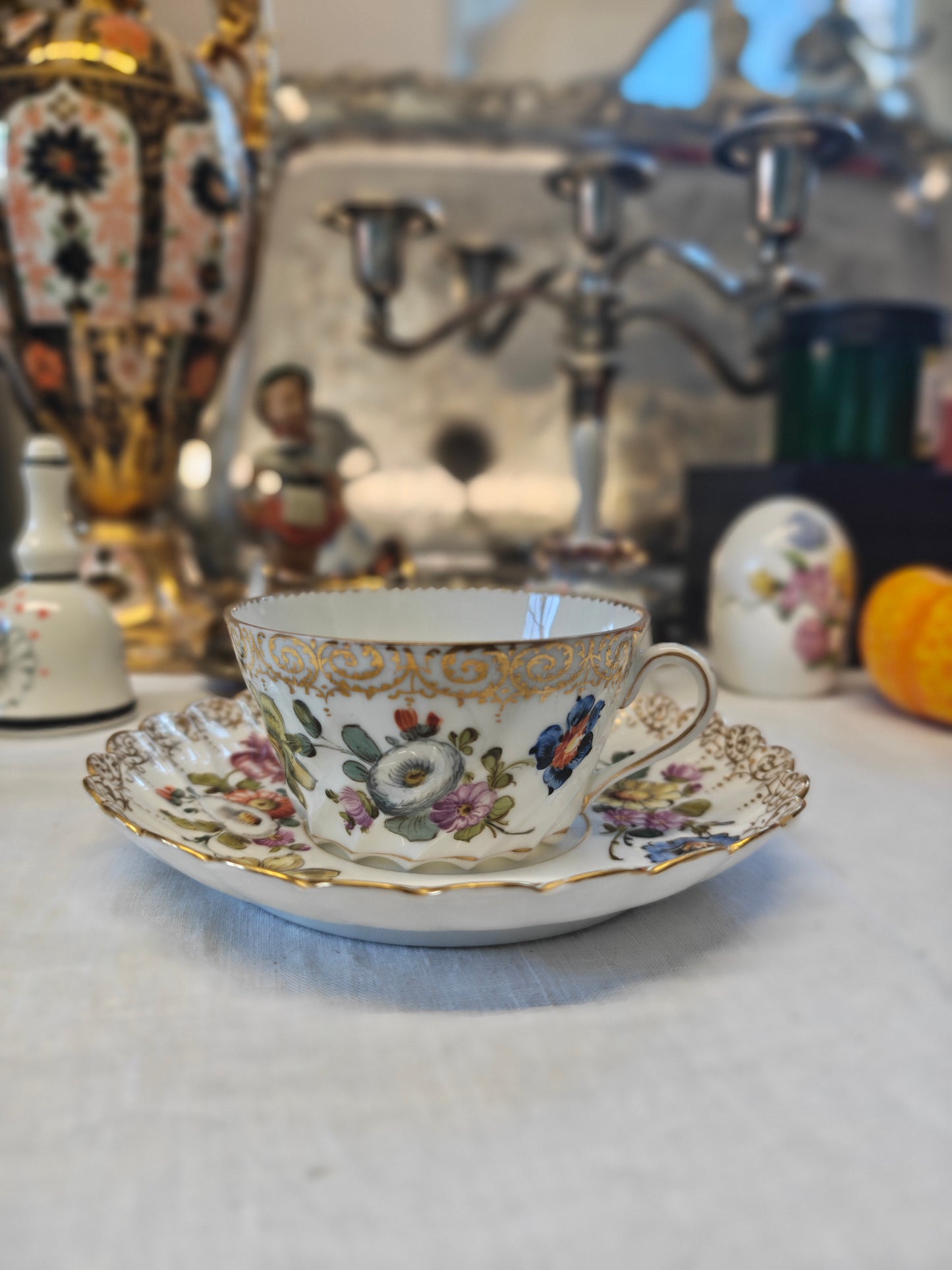 Dresden tea cup and saucer set features a delicate floral design with intricate gold accents