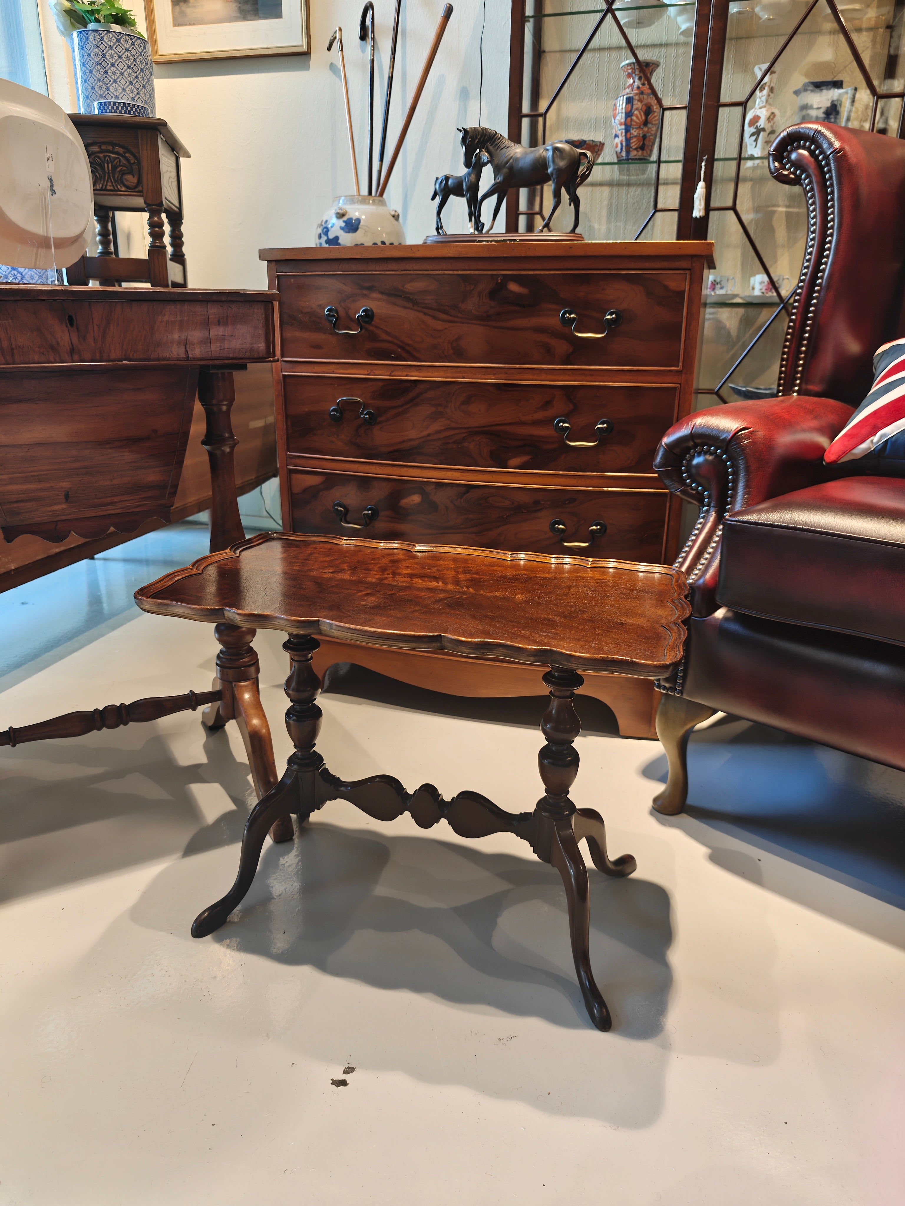 Antique mahogany table features a distinct pie-crust edge and a beautifully shaped stretchered base