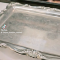 Silver tray with intricate designs on a reflective surface