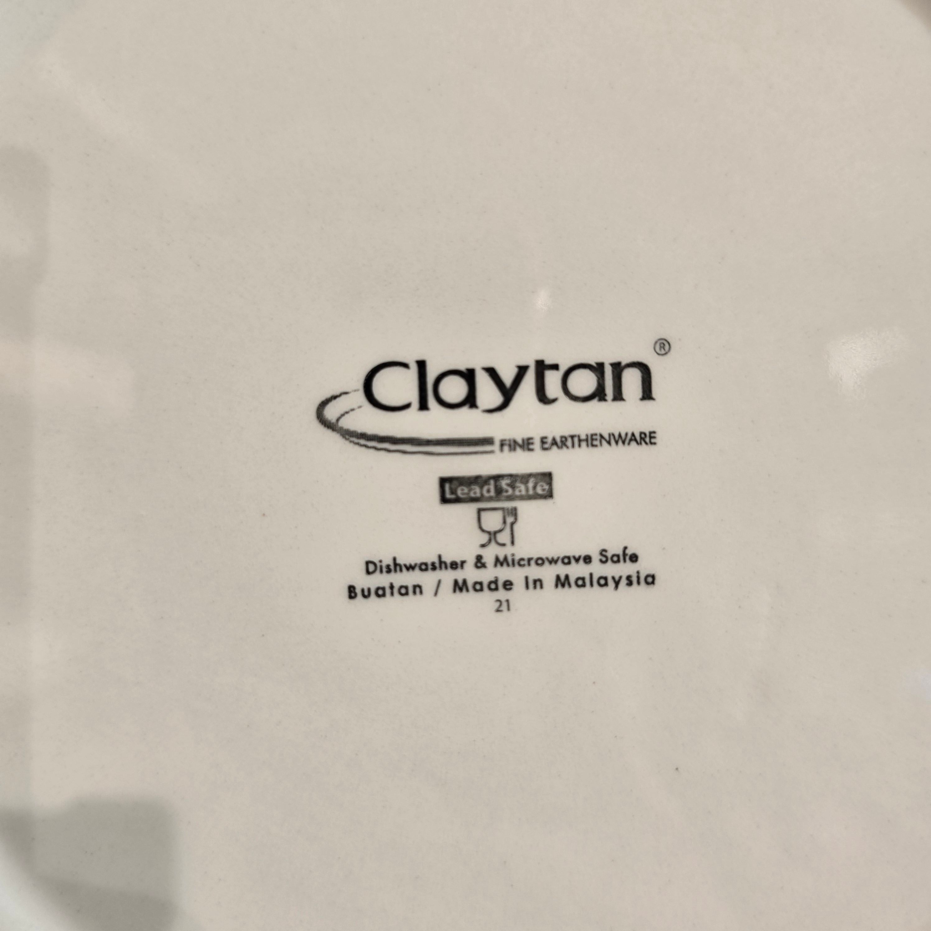 Claytan logo on a white ceramic plate