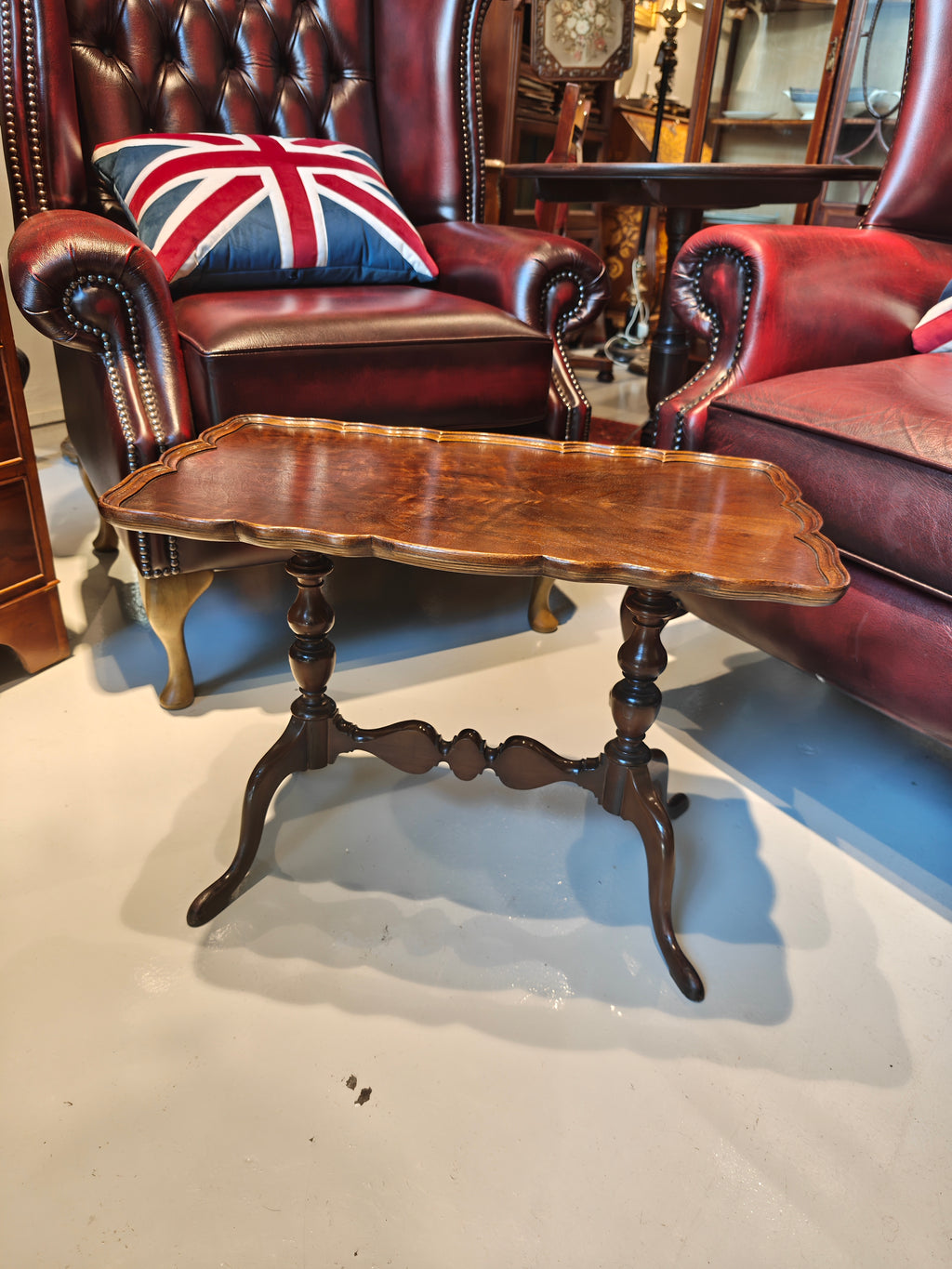 Antique mahogany table features a distinct pie-crust edge and a beautifully shaped stretchered base