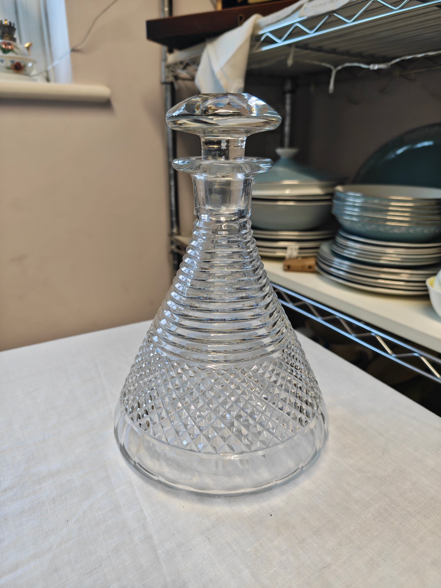 19th century crystal ships decanter with a diamond cut pattern on the base and a stepped prism design on the neck