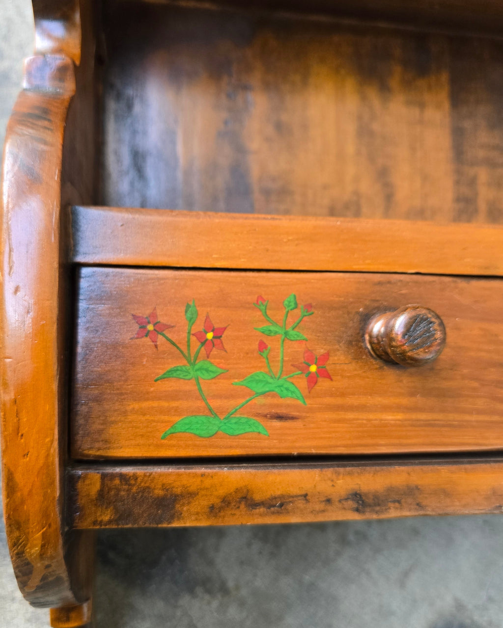 Wooden object with floral design on a gray surface