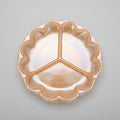 An iridescent orange glass three-piece serving tray with a scalloped rim, shown on a dark wooden tabletop.