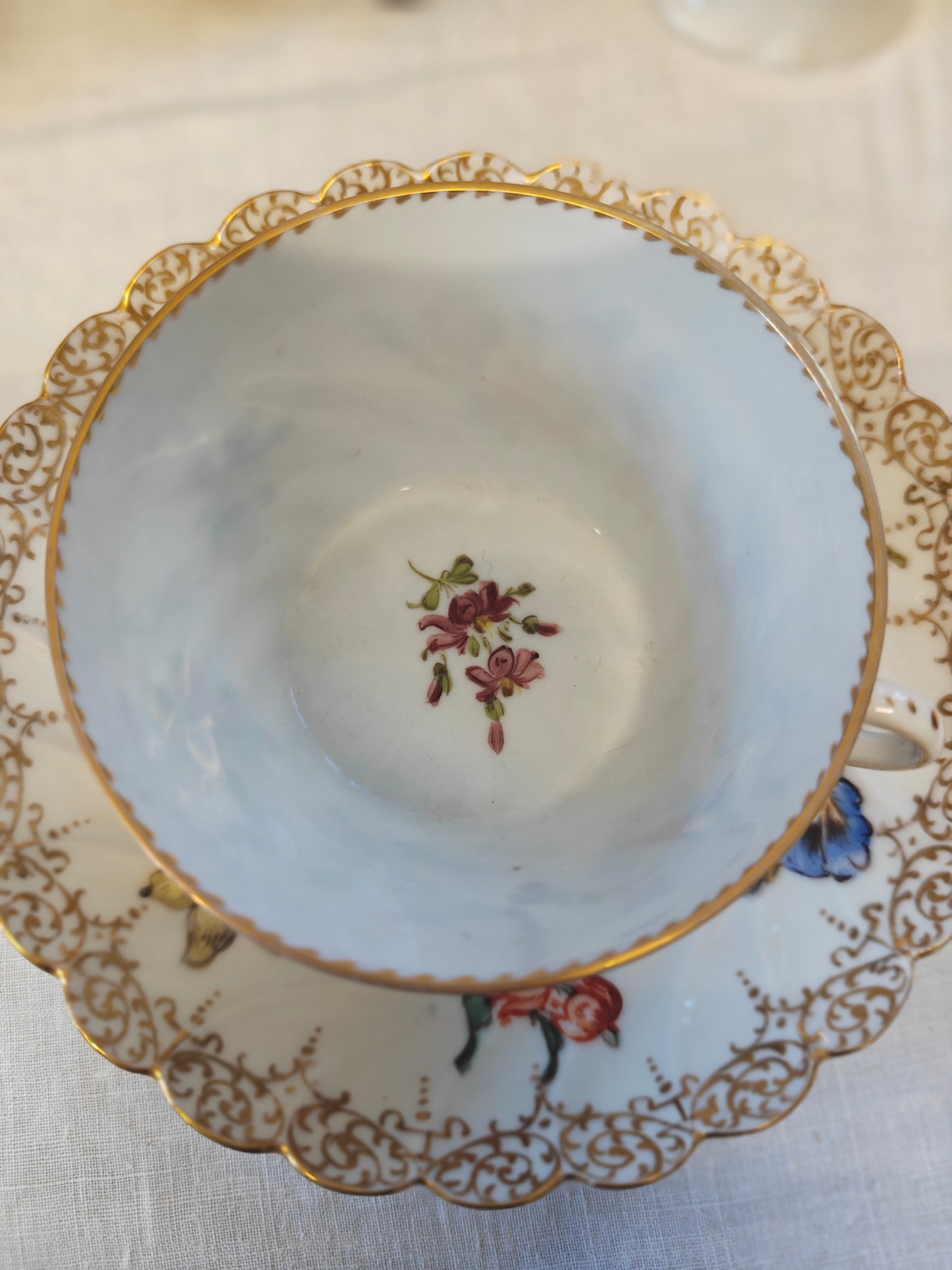 Dresden tea cup and saucer set features a delicate floral design with intricate gold accents