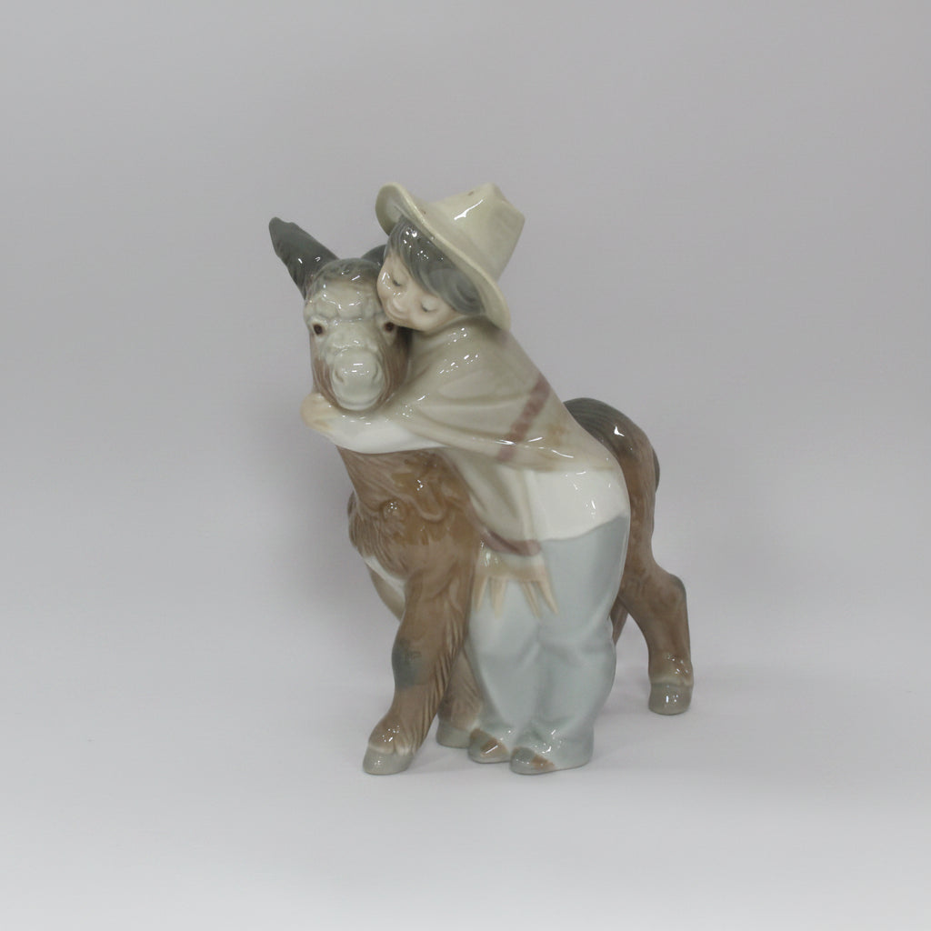 A collection of decorative items on a white studio background, including four small porcelain figurines and a large dark red crystal candle holder with hanging clear crystals.