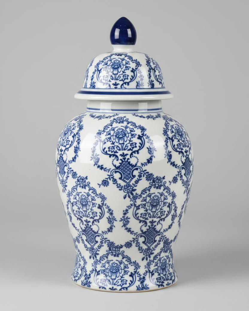 A vintage blue and white ginger jar with a floral pattern, featuring a lid with a black handle.